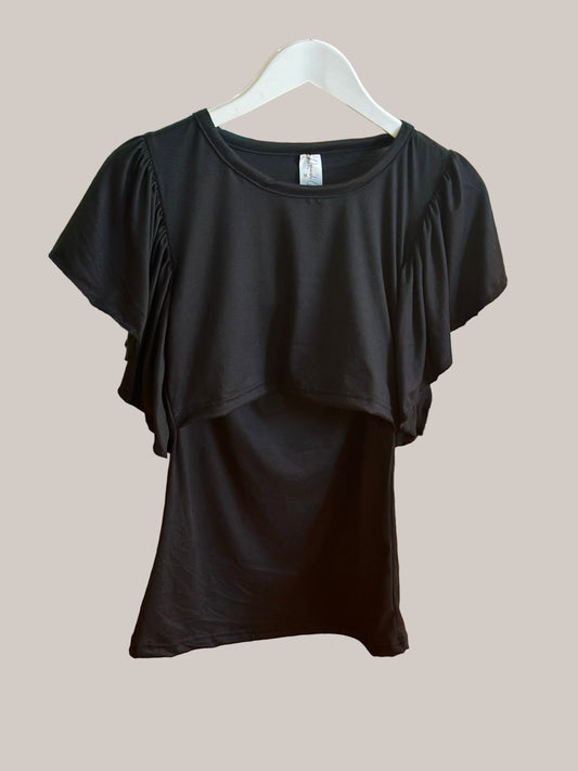 Black top on a hanger against a wooden floor background